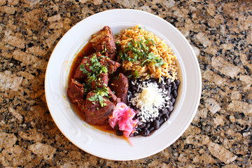 Cochinita pibil plate with pork served  beans, and rice.