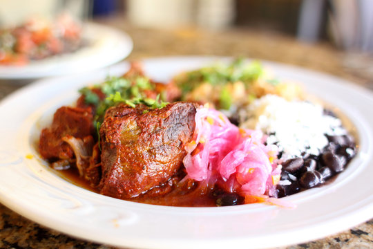 Cochinita pibil plate with pork served beans, and rice.