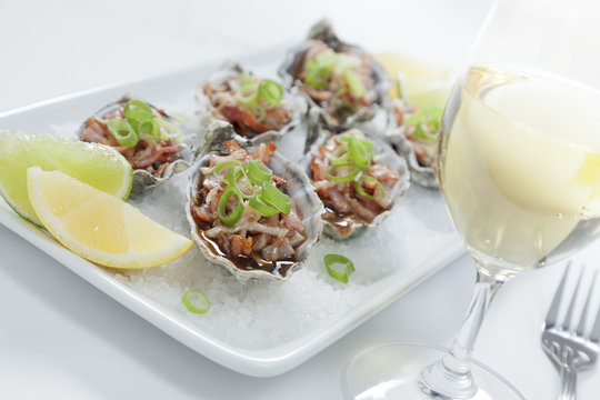 Oven baked oysters kilpatrick on a bed of rocksalt