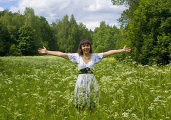 Naklejka na ściany i meble Young woman in white dress on a meadow in blossom