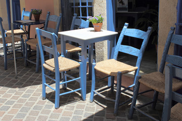 Fototapeta na wymiar Niebieskie krzesła w tawernie na Krecie