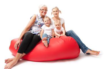mother daughter and grandchildren on a red sofa