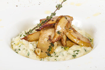 photo of delicious risotto dish with herbs and mushrooms on whit