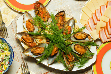 Mussels in a white plate  on the table.