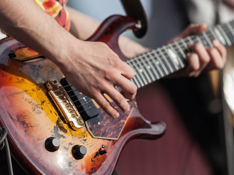 Human hand holding guitar music instrument