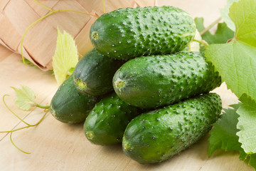 cucumbers with leaves on wooden table