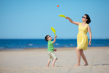 Young mother and son playing on the beach