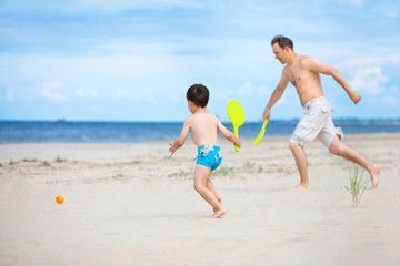 Fototapeta na wymiar Ojciec i syn gra na plaży