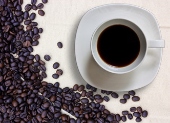 Coffee cup and grain on background