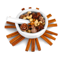 Composition of mortar with nuts and cinnamon isolated on white