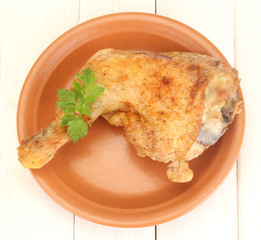 roasted chicken leg with parsley in the plate