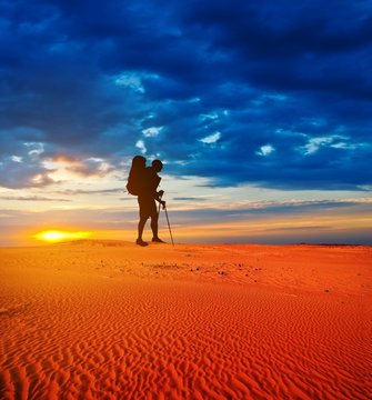tourist in a sand desert at the sunset