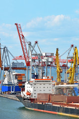 Fototapeta premium Container stack and ship under crane bridge