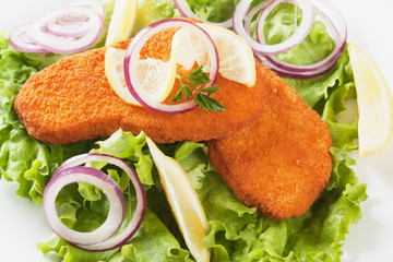 Breaded fish steaks with lemon and lettuce