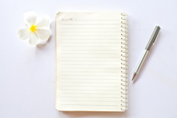 notebook with pen and flower