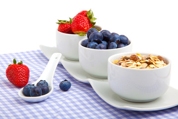 fresh berries in porcelain bowls, on white background