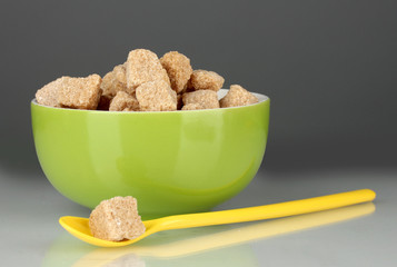Colorful bowl with brown cane sugar cubes with colorful spoon
