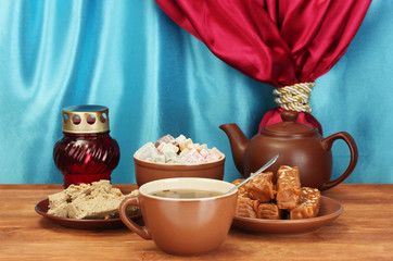 Teapot with cup and saucers with oriental sweets - sherbet