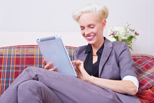 Frau auf Sofa mit Tablet Computer