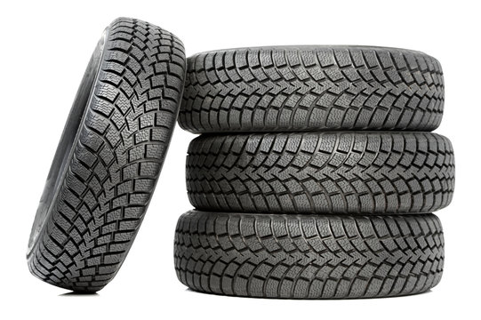 Stack of four car wheel winter tires isolated