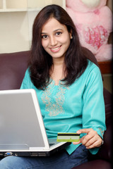 Happy Indian woman online shopping from home