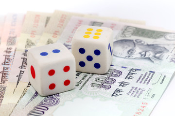 Dice on rupee coins on Indian currency notes