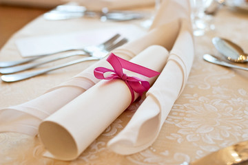 Banquet table setting with menu tied with pink ribbon