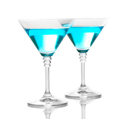 Blue cocktail in martini glasses isolated on white