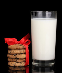 Glass of milk and cookies isolated on black