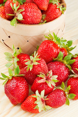 strawberries in basket on wooden board