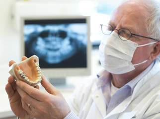 adult dentist looking at dentures