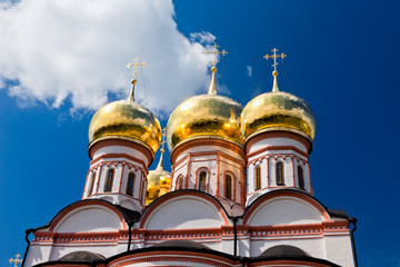Fototapeta na wymiar Cupolas of Russian orthodox church against blue sky