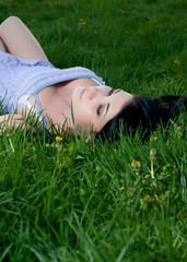 Woman lies on her back in grass.