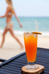 Orange juice in glass with ice, straw and fruit slice
