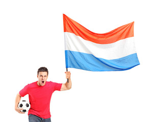 An euphoric fan holding a ball and waving a dutch flag