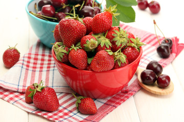 Ripe strawberries and cherry berries in bowls