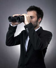 Young businessman with binoculars