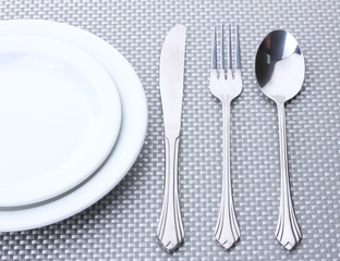 White empty plates with fork, spoon and knife