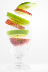 Slices apple falling into a glass 