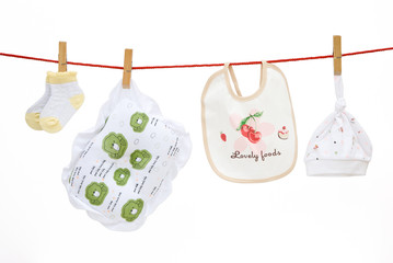 baby socks and pillow and bib and cap hanging with clipping path