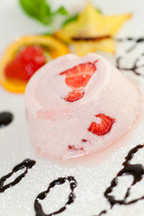 Italian dessert panna cotta on white plate decorated with strawb