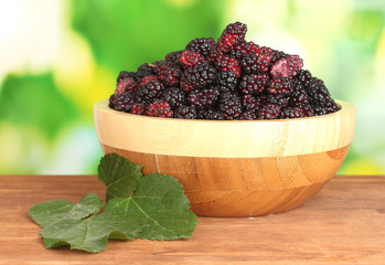 Wooden bowl with ripe mulberries
