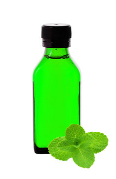 Close up of medicine bottle with green syrup and mint herb isola
