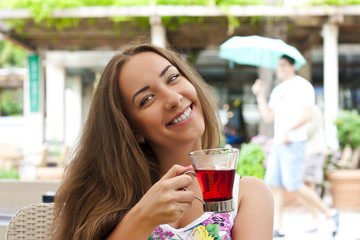 Young woman drinking tea in a cafe outdoors