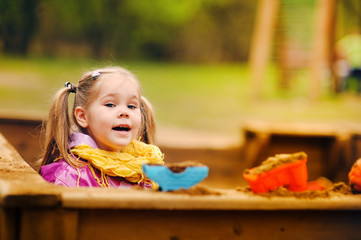 cute little girl playing in a sandbox