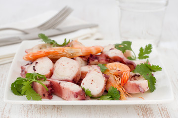seafood salad with parsley on plate and glass of water