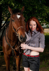 Fototapeta premium woman with red hair sitting on a horse
