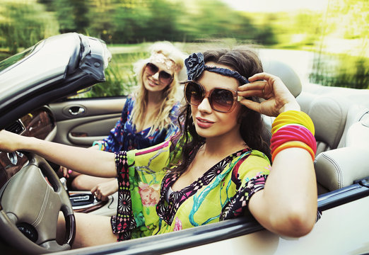 Two young women driving a car