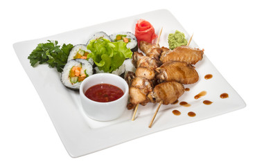 Buffalo chicken wings on plate with sushi