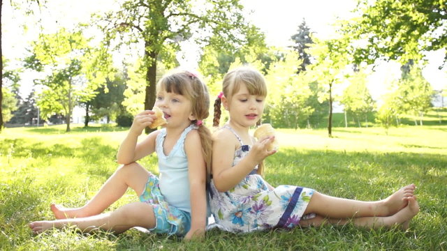 Children eating ice cream. Sitting on the grass